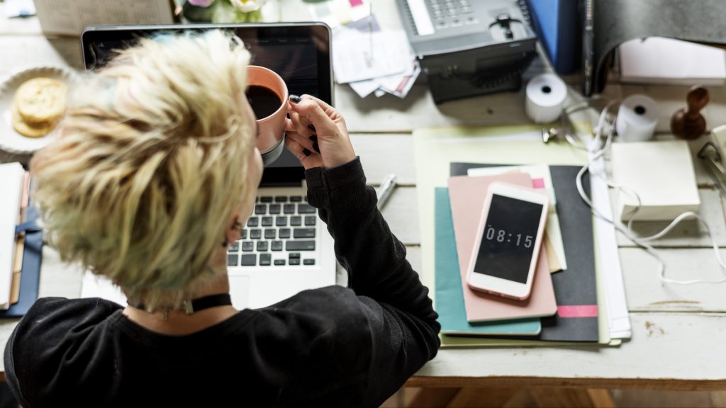 Woman Hands Holding Coffee Cup Working on Laptop